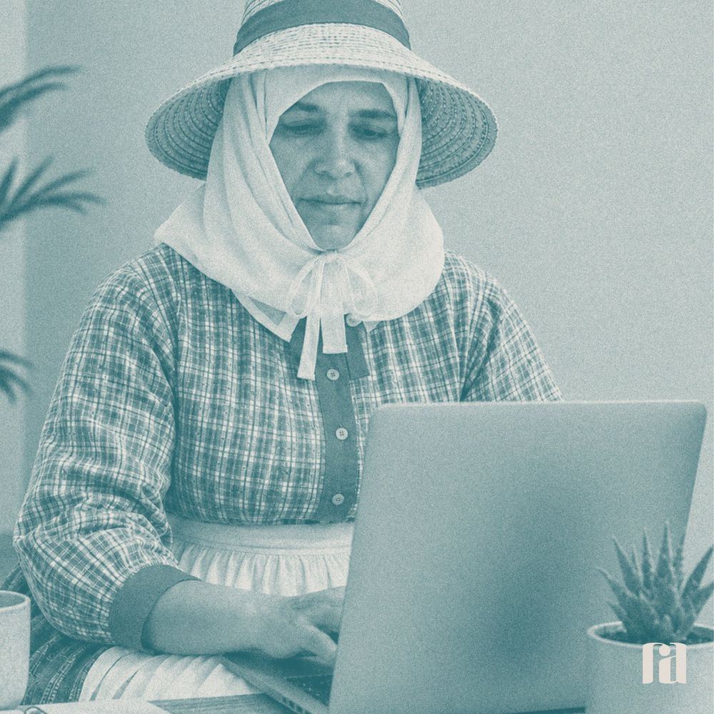 Mujer con sombrero y pañuelo tradicional trabajando con un portátil
